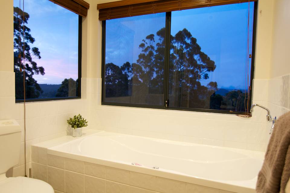 The bath in the Tingle chalet with windows looking out to the sunset.